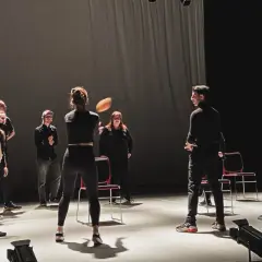 Schauspieler proben auf der Bühne, eine Frau wirft einen Ball. Viele improtheater ideen entstehen in solchen Momenten.