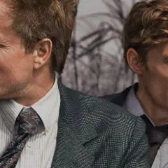 Zwei Männer in Anzügen, die an einer düsteren Ermittlung in einer der besten crime serien arbeiten.
