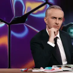 Mann mit nachdenklichem Blick hinter einem Schreibtisch, im Hintergrund eine abstrakte, bunte Wand und ein Fernglas mit seltsamen Symbolen, die wie gibberish language wirken.