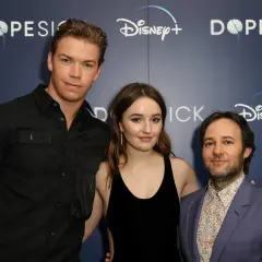 Die Besetzung von Dopesick: Will Poulter, Kaitlyn Dever und Michael Keaton posieren vor dem Disney+ Logo.