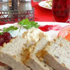 Gegrillte Pastete mit Preiselbeeren, Tomaten und einer cremigen Beilage. Eine köstliche Mahlzeit, die man nicht als Farce bezeichnen kann.