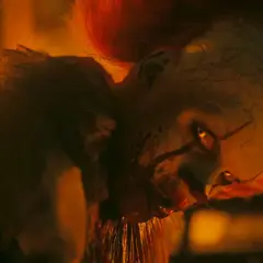 Pennywise, der Clown, blickt mit leuchtenden Augen aus dem Feuer. Willkommen in Derry, wo er auf seine Opfer wartet.