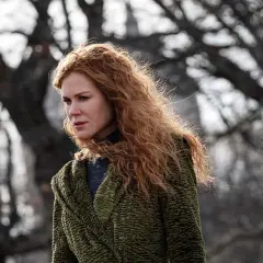 Nicole Kidman mit roten Haaren, im grünen Mantel, blickt nachdenklich in die Ferne. Ein Moment des "the undoing" in der Natur.