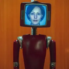 Ein roter Roboter mit einem Bildschirm, auf dem das Gesicht einer Frau zu sehen ist. Dies ist die Besetzung von Cassandra.