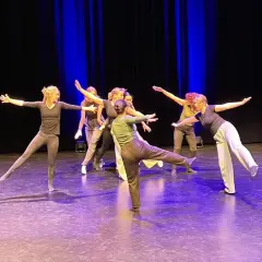 Tänzerinnen auf einer Bühne, die eine Choreografie für ein klassisches Musical aufführen.