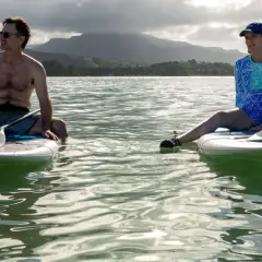 Ein Mann und eine Frau auf Stand-Up-Paddleboards im Meer, eine Szene aus der "four seasons serie".