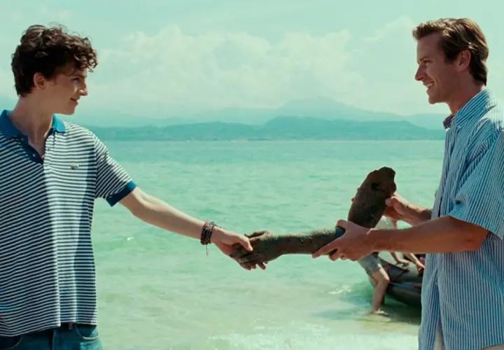 Besetzung von Call Me By Your Name: Elio und Oliver am See, Oliver hält eine Statue.