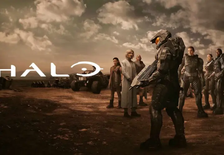 Die Besetzung von Halo (Fernsehserie) steht in einer staubigen Landschaft. Im Vordergrund ein Master Chief, im Hintergrund das Halo-Logo und weitere Charaktere.
