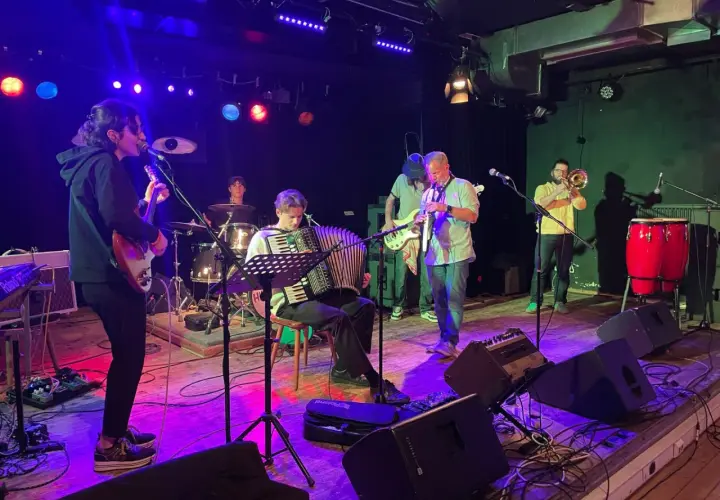 Band jammt Musik, die Bedeutung von Gemeinschaft und Kreativität. Akkordeon, Gitarre, Trompete und Schlagzeug.