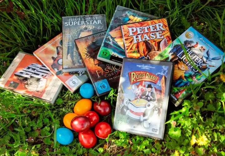 Osterfilm-Spaß für Kinder: DVDs wie "Peter Hase" und "Roger Rabbit" liegen neben bunten Eiern im Gras.