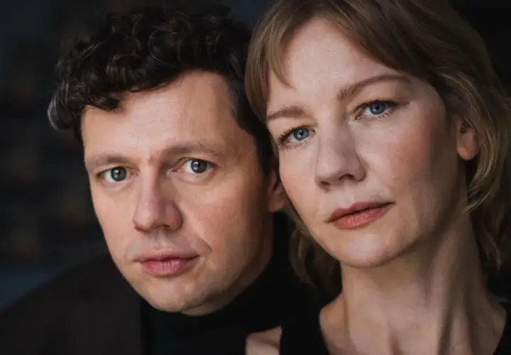 Nahaufnahme der Gesichter von Christian Friedel und Sandra Hüller, der Hauptdarsteller der besetzung von The Zone of Interest.