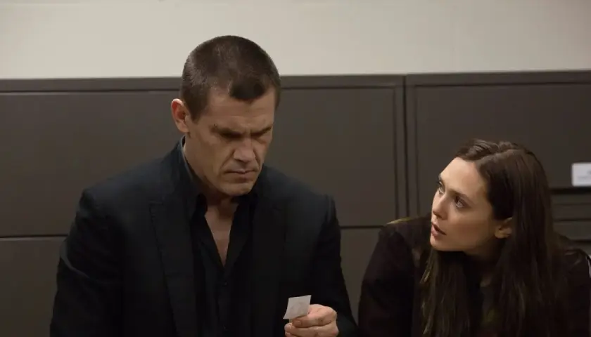 Josh Brolin und Elizabeth Olsen in einer Szene aus der Besetzung von Oldboy. Er betrachtet ein kleines Stück Papier, sie schaut ihn besorgt an.