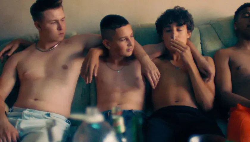 Vier Jungs auf einer Couch, die Sonne scheint, aber sie sind drinnen, umgeben von Beton.