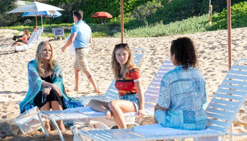 Drei Frauen entspannen am Strand. Jennifer Coolidge in "The White Lotus" Staffel 1.