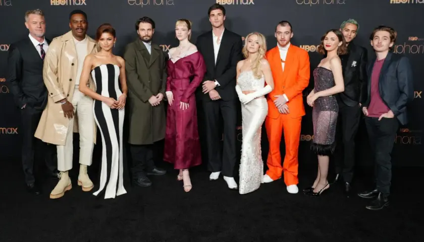 Die Besetzung von Euphoria posiert auf dem roten Teppich. Zendaya trägt ein schwarz-weiß gestreiftes Kleid, Sydney Sweeney ein glitzerndes weißes Kleid.