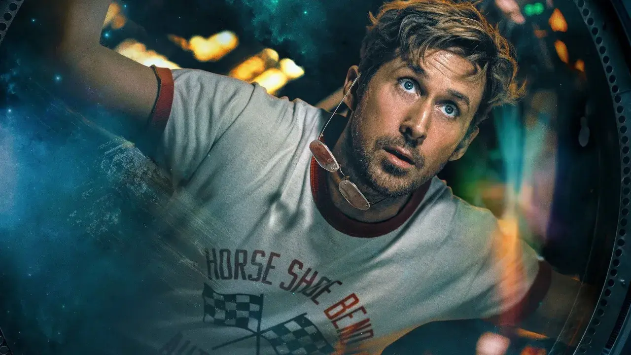 Der Astronaut blickt mit weit aufgerissenen Augen in den Weltraum. Sein T-Shirt trägt die Aufschrift "Horse Shoe Bend".