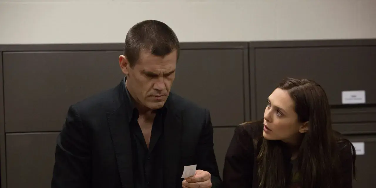 Josh Brolin und Elizabeth Olsen in einer Szene aus der Besetzung von Oldboy. Er betrachtet ein kleines Stück Papier, sie schaut ihn besorgt an.