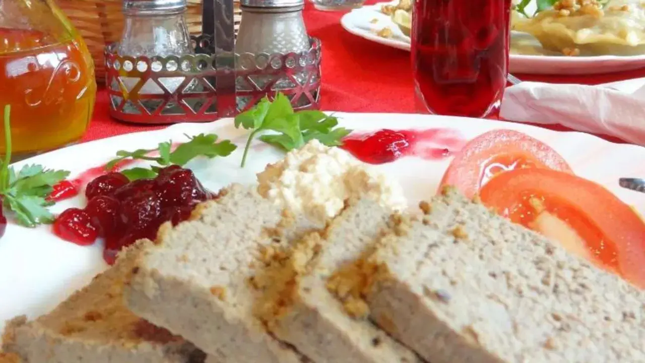 Gegrillte Pastete mit Preiselbeeren, Tomaten und einer cremigen Beilage. Eine köstliche Mahlzeit, die man nicht als Farce bezeichnen kann.
