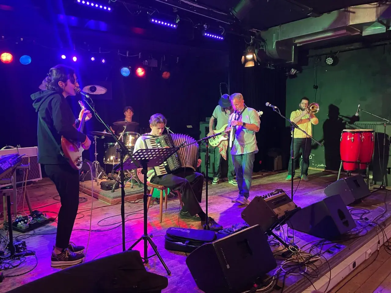 Band jammt Musik, die Bedeutung von Gemeinschaft und Kreativität. Akkordeon, Gitarre, Trompete und Schlagzeug.