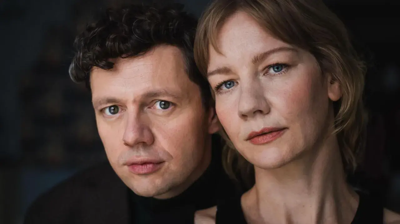 Nahaufnahme der Gesichter von Christian Friedel und Sandra Hüller, der Hauptdarsteller der besetzung von The Zone of Interest.