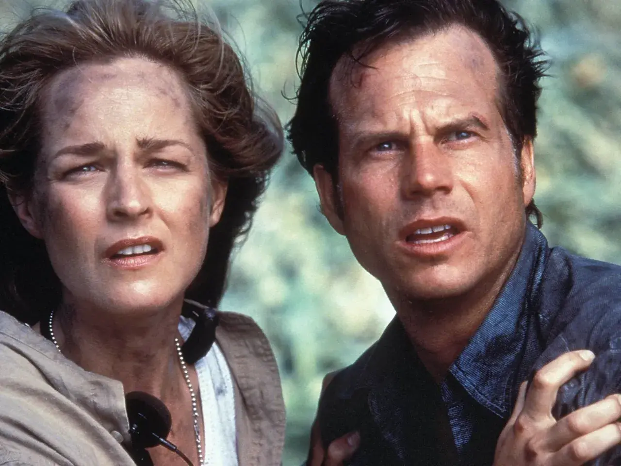 Helen Hunt und Bill Paxton, die Hauptdarsteller von Twisters, blicken besorgt in die Ferne.