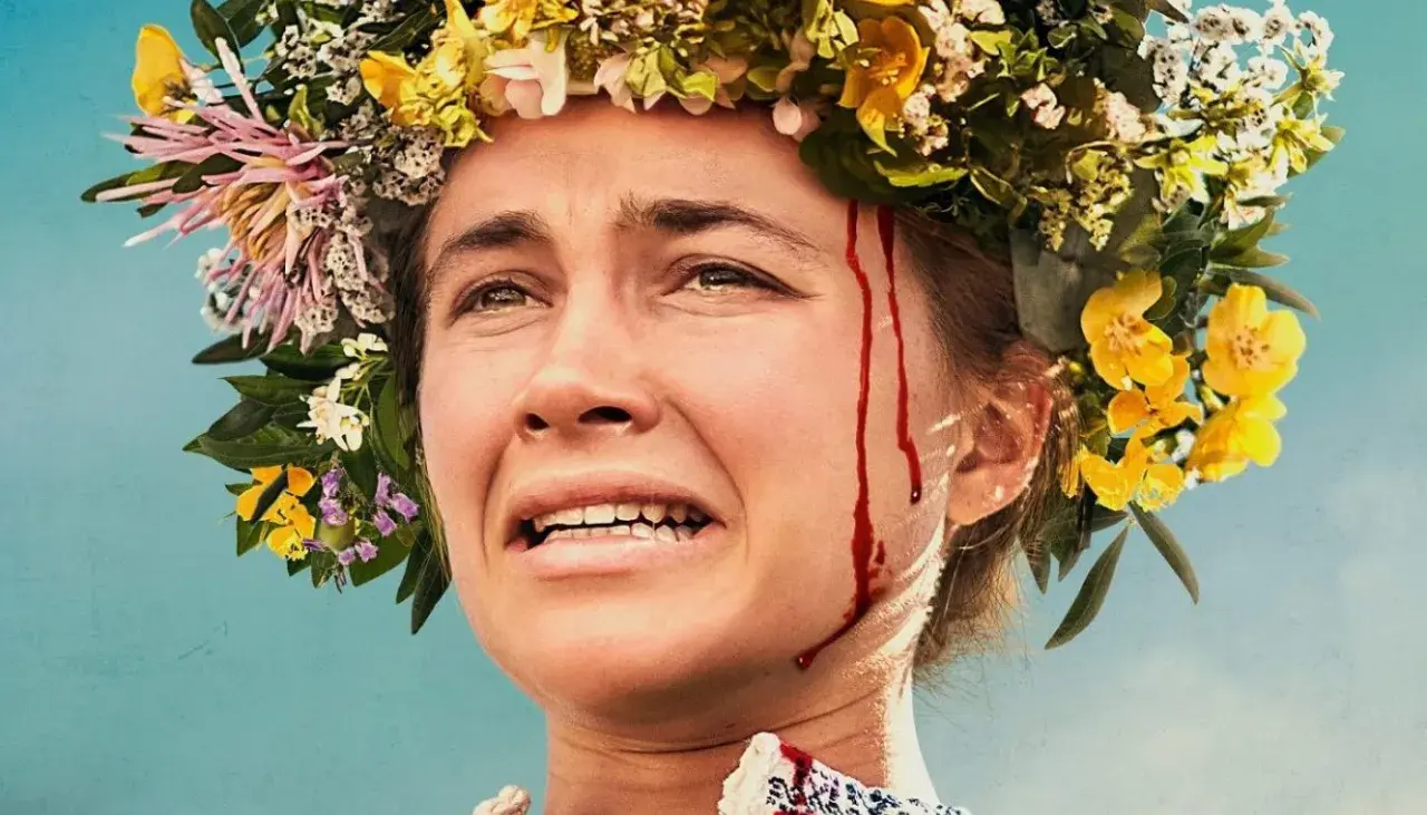 Nahaufnahme einer Frau mit Blumenkranz und Blutspuren im Gesicht. Die besetzung von Midsommar zeigt eine Frau in emotionaler Not.