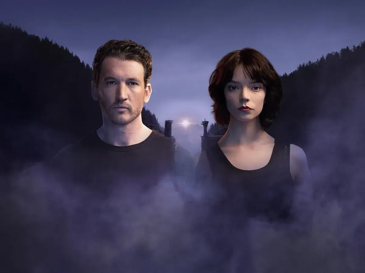 Ein Mann und eine Frau stehen im Nebel vor einer düsteren Berglandschaft. Das ist ein Bild aus "The George Film".