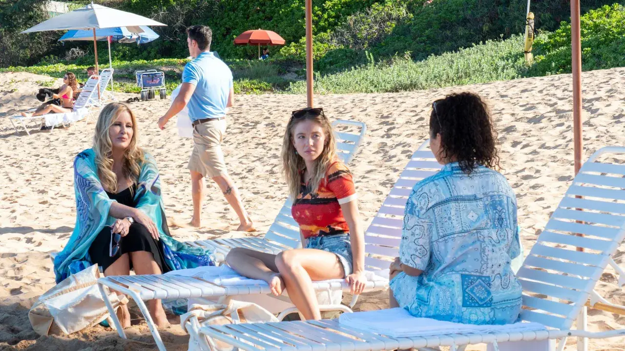Drei Frauen entspannen am Strand. Jennifer Coolidge in "The White Lotus" Staffel 1.