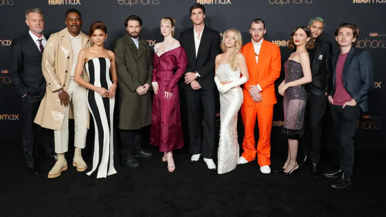 Die Besetzung von Euphoria posiert auf dem roten Teppich. Zendaya trägt ein schwarz-weiß gestreiftes Kleid, Sydney Sweeney ein glitzerndes weißes Kleid.