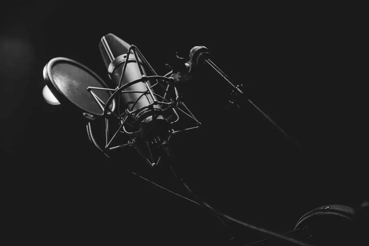 Ein Mikrofon mit Popschutz im Studio, bereit f&uuml;r einen lustigen Podcast.