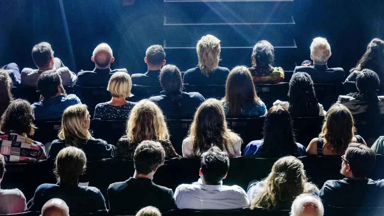 Publikum im Dunkeln, gespannt auf das, was kommt. Die Bedeutung von improvisieren liegt im Moment, im spontanen Schaffen.