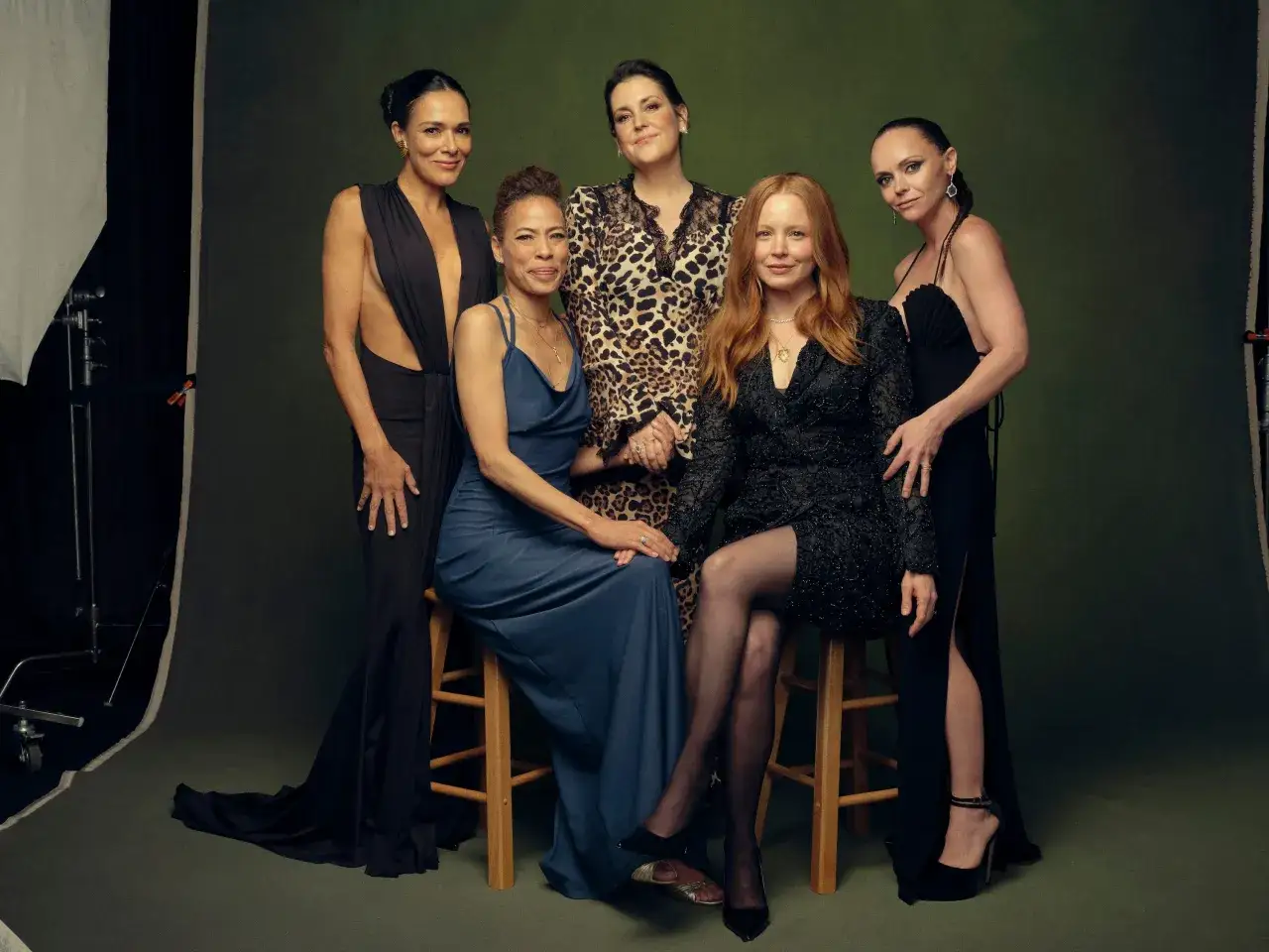 Die Besetzung von Yellowjackets, f&uuml;nf Frauen in eleganten Kleidern, posieren vor einem gr&uuml;nen Hintergrund.