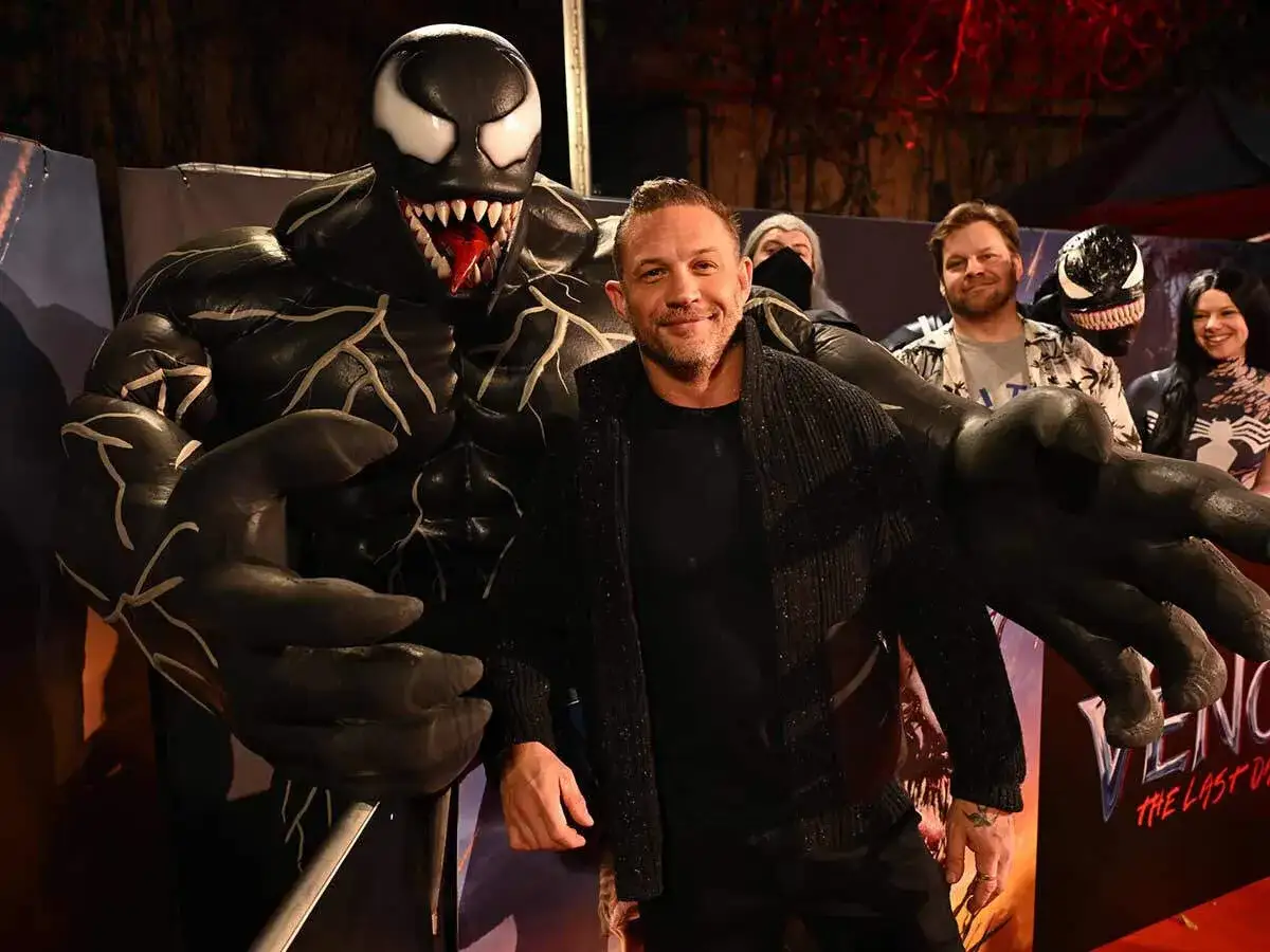 Tom Hardy posiert mit einer riesigen Venom-Figur. Die Besetzung von Venom: The Last Dance feiert den Film.