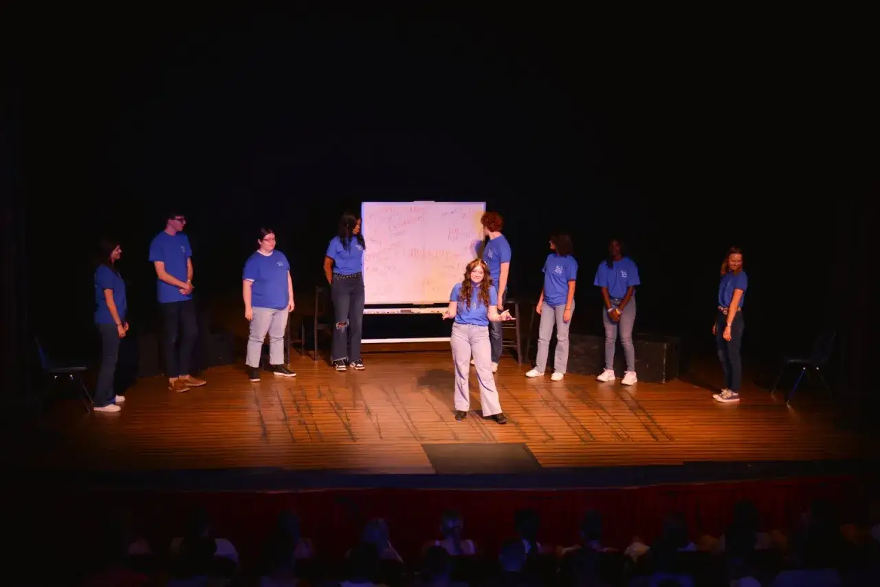 Eine Gruppe von Schauspielern sammelt improtheater ideen vor einer Tafel mit Stichwörtern.