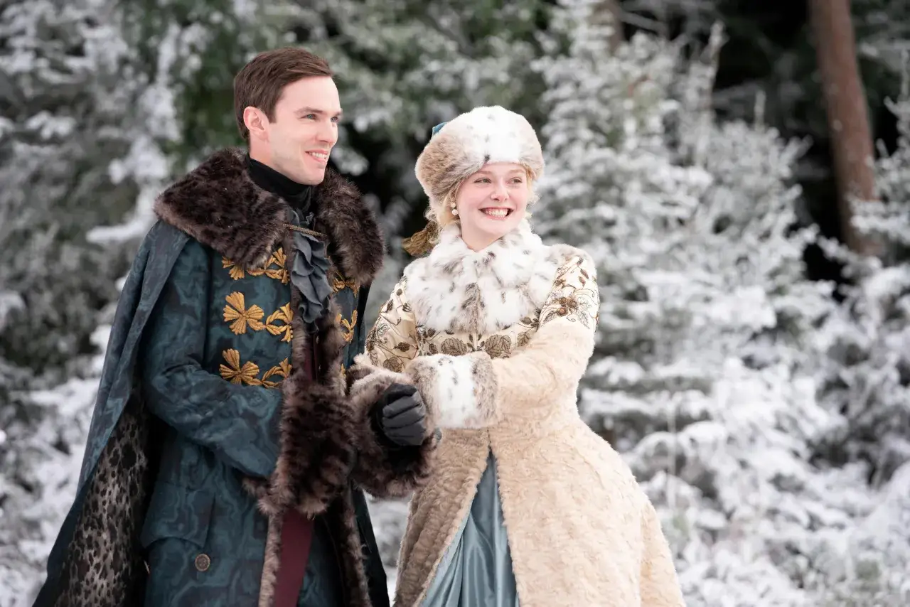 Ein Mann und eine Frau in prächtigen Winterkleidern stehen im Schnee. Sie scheinen die Kälte zu genießen, die Frau lacht fröhlich. Ein großartiger Moment im Schnee.