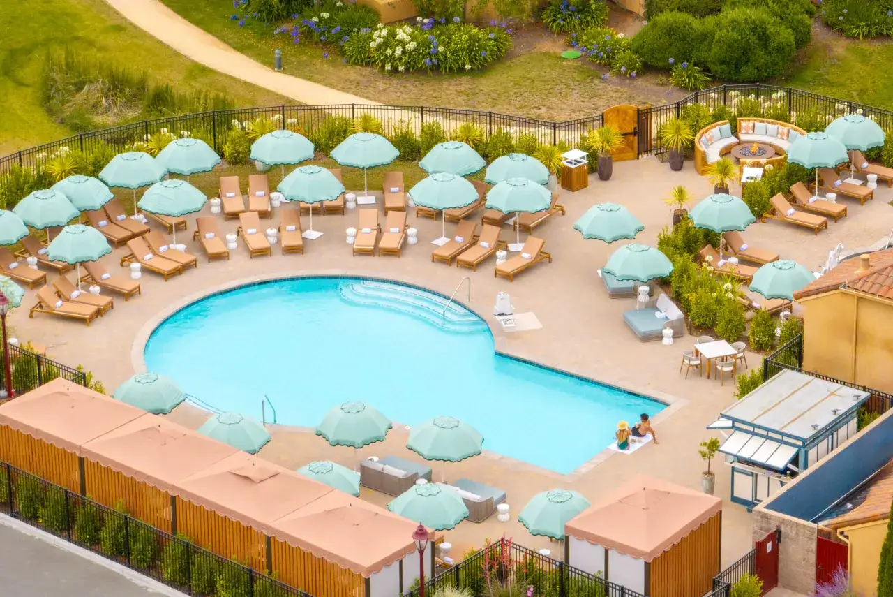 Ein luxuri&ouml;ser Poolbereich mit Liegest&uuml;hlen und Sonnenschirmen, wie in 