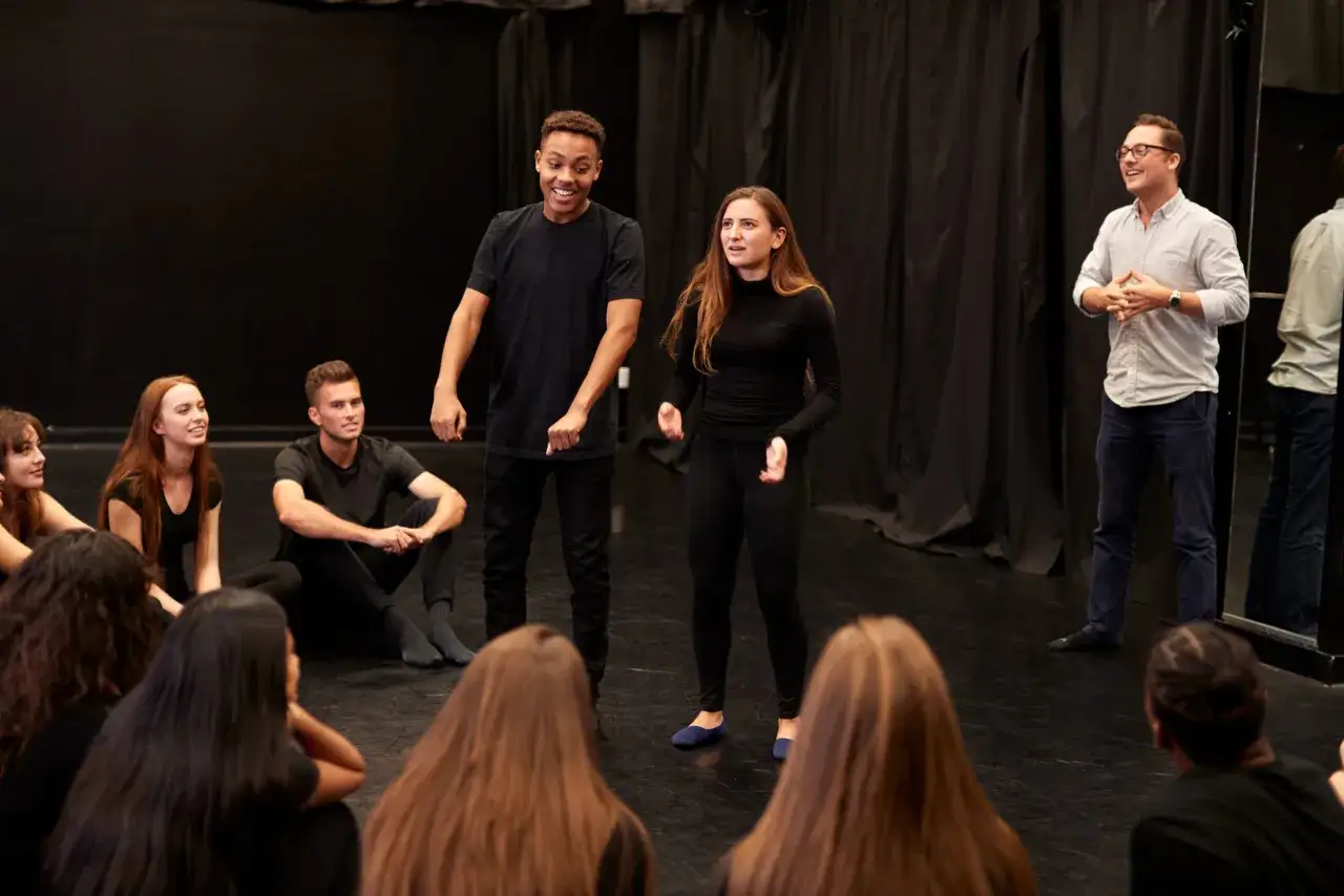 Schauspieler &uuml;ben im Kreis, was ist Method Acting? Ein Lehrer erkl&auml;rt, w&auml;hrend zwei Sch&uuml;ler aufstehen und eine Szene spielen.